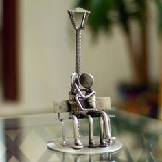 a silver figurine sitting on top of a glass table