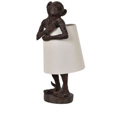 a lamp that is shaped like a monkey with a white lampshade on it