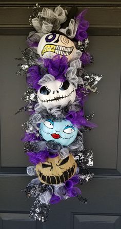 halloween decorations hanging on the front door with purple and silver ribbons, skulls and skeletons