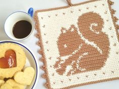 a crocheted placemat with a hot dog on it next to some heart shaped cookies