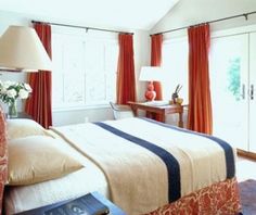 a bed room with a neatly made bed next to two lamps and a sliding glass door