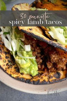 some tacos with meat and lettuce in them on a plate that says 30 minute spicy lamb tacos