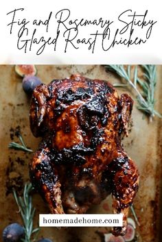 a roasted chicken on a baking sheet with rosemary sprigs and blueberries in the background