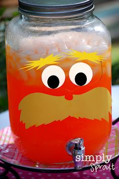 a glass jar filled with liquid and a face painted on the lid, sitting on top of a table