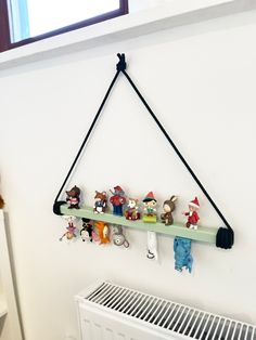 there is a shelf with toys on it in the corner next to a radiator