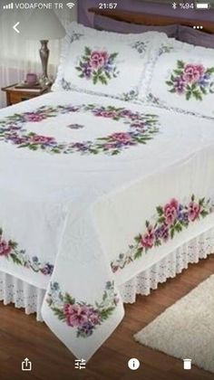 a bed with white bedspread and pink flowers on it