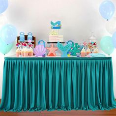 a table topped with lots of cake and balloons