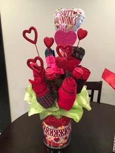 a valentine's day arrangement in a jar on a table