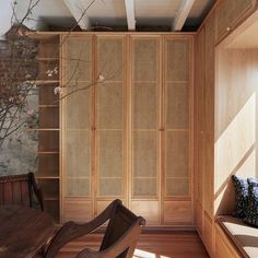 a room with a wooden table and chair next to a book shelf filled with books