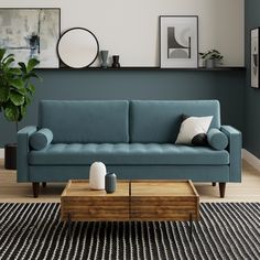 a living room with a blue couch, coffee table and pictures on the wall above it