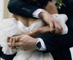 a bride and groom are hugging each other