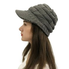 a woman with long hair wearing a gray knitted hat on her head, side view