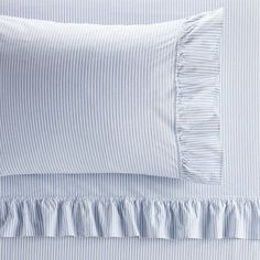 the blue and white bedding has ruffled trims on it's edges