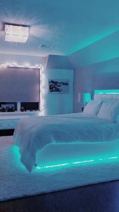 a large bed sitting in a bedroom next to a window with blue lights on it