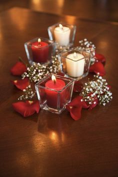 some candles are sitting on a table with flowers