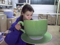 a woman holding a large green coffee cup