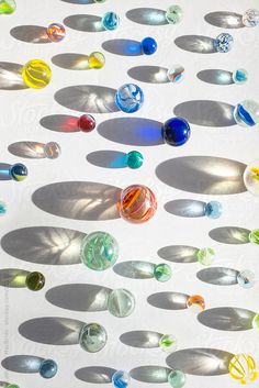 many different colored marbles are arranged on a white surface by jodi lenski for stocks & bond
