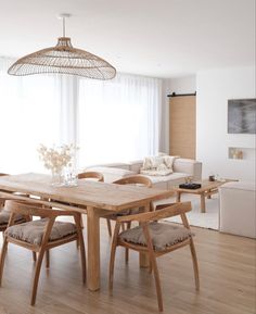 a dining room table with four chairs and a light fixture hanging over it's head