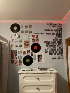 a bedroom with records on the wall next to a dresser