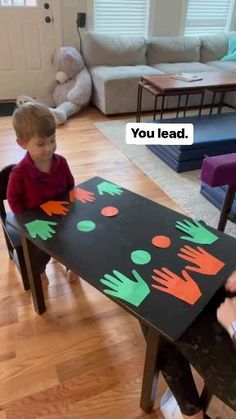 two children sitting at a table with hand prints on it