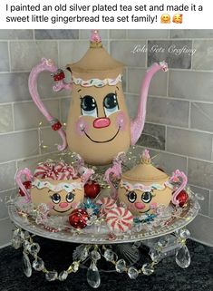 a tea pot and two cups on a cake stand with candy canes in front of it