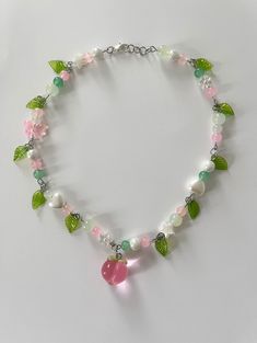 pink and green beaded necklace with pink peach charm. whimsical fairy like necklace with green leaf charms. silver metal Pink Fairy Jewelry, Pink And Green Necklace, Beaded Necklace Inspiration, Pink And Green Aesthetic, Green Beads Necklace, Collar Rosa, Peach Necklace, Бисер Twin, Necklaces Beaded