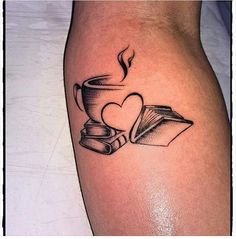 a tattoo on the leg of a woman with books and a cup