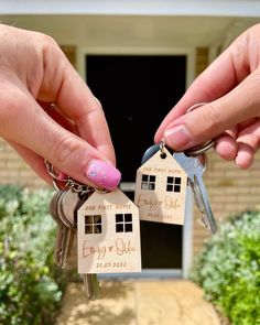 two hands holding keys to a house shaped keychain with the words family and home on it