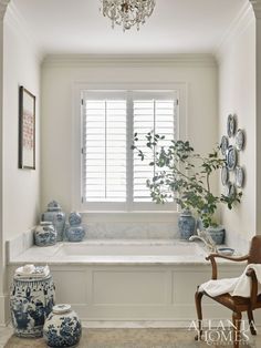 a white bathroom with blue vases and a chandelier hanging from the ceiling