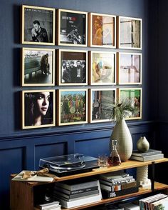 there are many pictures hanging on the wall in this living room, and one is holding a record player