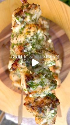 chicken skewers with broccoli and cheese on a wooden plate