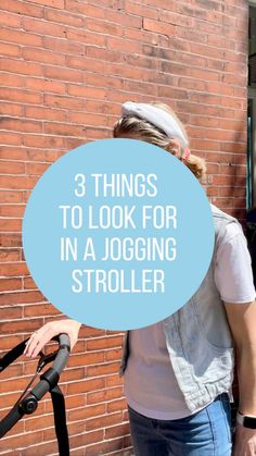 a woman standing next to a brick wall with the words 3 things to look for in a jogging stroller