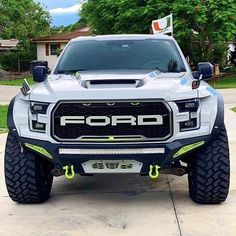 the front end of a white truck parked in a driveway