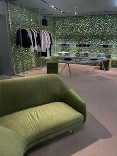 a corner in the prada store on rodeo drive including a green couch, a glass table with books on it, and a rack and shelves on the wall holding clothes Green Aesthetic Prada, Vision Board Green Aesthetic, Vision Board Green, Aesthetic Prada, Aesthetic Closet, Prada Store, Prada Aesthetic, Aesthetic Vision Board, Aesthetic Shopping