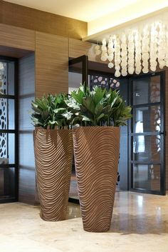 two large planters with plants in them on the floor