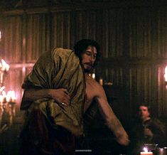 a man in a bathrobe with candles around him