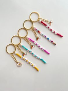 six keychains with different designs on them sitting next to each other in the shape of letters