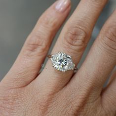 a woman's hand with a diamond ring on it