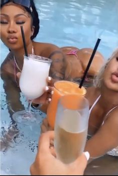 two women are in the pool with drinks