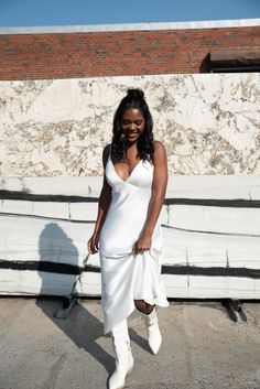 a woman in a white dress and boots