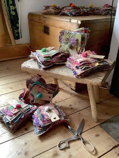 several pieces of fabric sit on a table with scissors and other items scattered around it