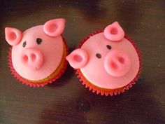 two cupcakes with pink frosting decorated like pigs