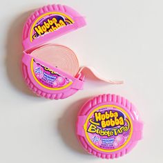 two pink plastic objects on a white surface with one being opened and the other is empty