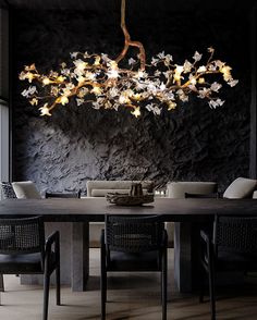 a dining room table with chairs and a chandelier hanging from it's ceiling