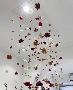 an art installation with flowers hanging from the ceiling