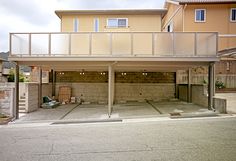 an empty parking garage in front of a two story house