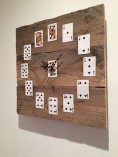a clock made out of wood with playing cards on the sides and numbers painted on each side