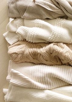 a pile of sweaters and blankets sitting on top of each other