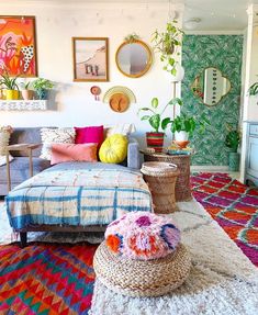 a living room filled with lots of colorful furniture and decor on top of a rug