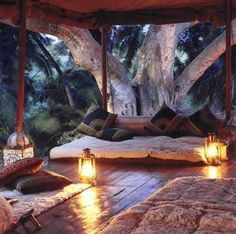 the inside of a tent with candles lit up in front of it and outside seating area